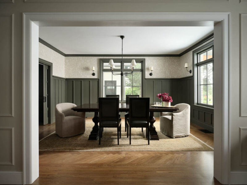 Traditional formal dining room with dark green wanescoting and trim