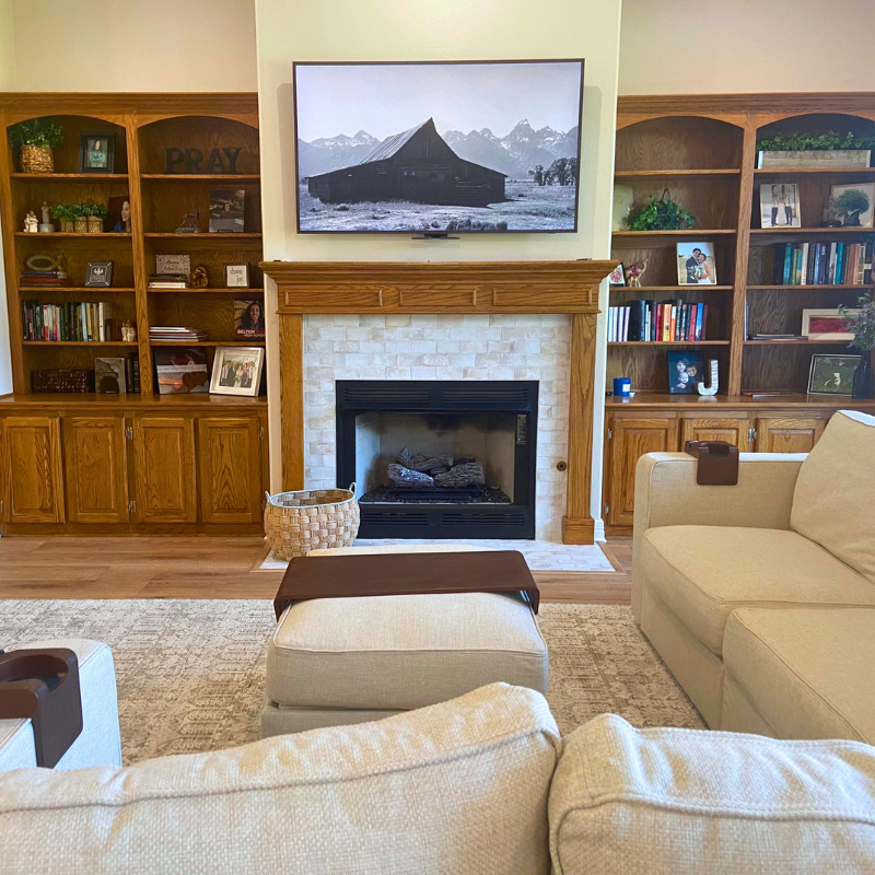 White tile fireplace with warm wood flooring in a rustic, modern living room.
