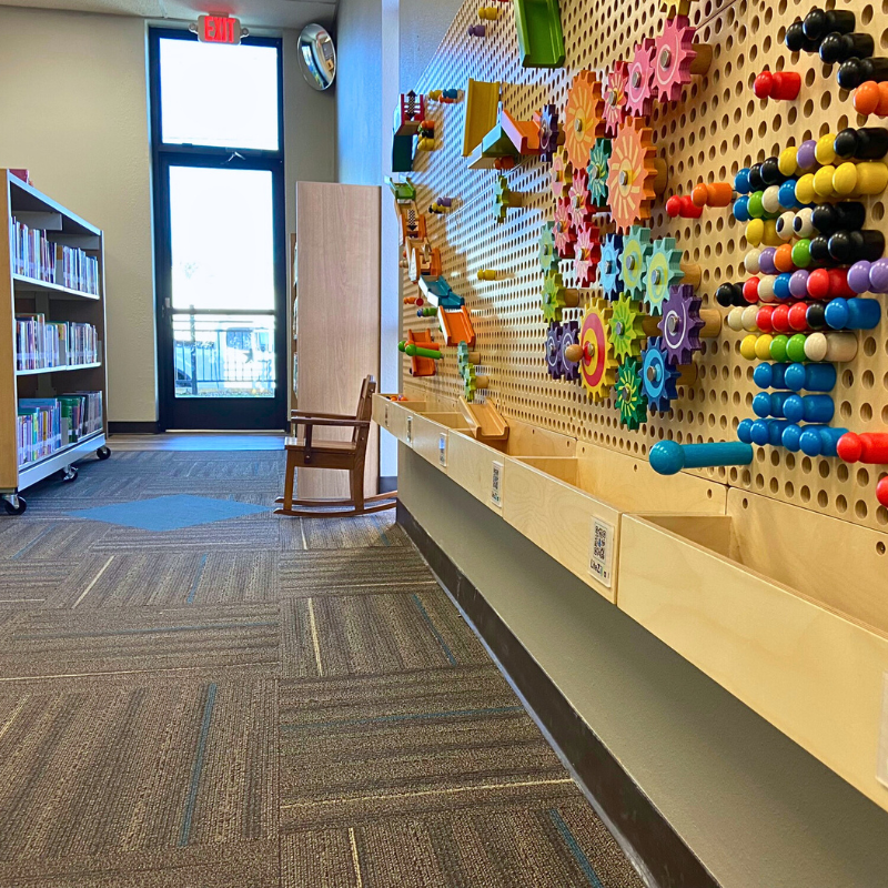 Modern, commercial carpet next to a kids' learning space with a peg board.