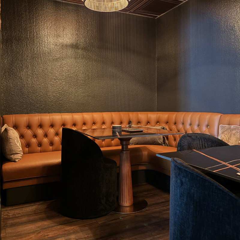 Dark, hardwood flooring in a moody, intimate lounge.